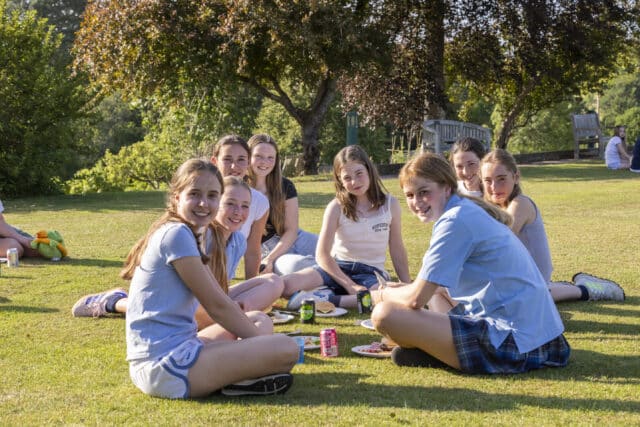 Cranleigh prep students sitting on the grass enjoying a summer bbq