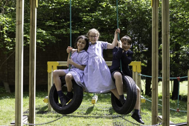 Cranleigh prep students playing on a tyre swing