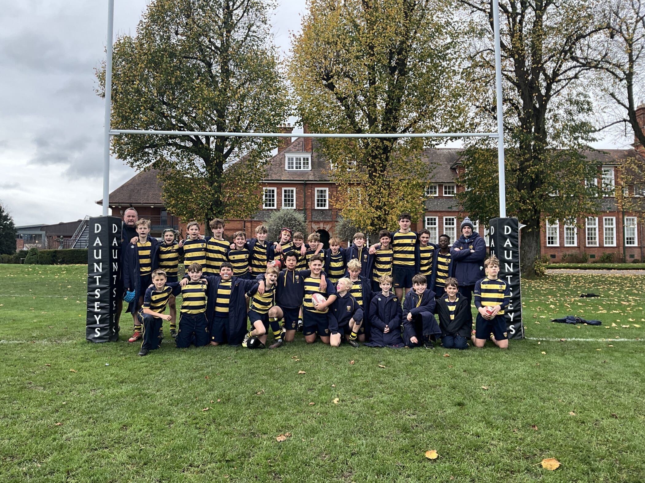 Cranleigh Rugby pupils posing next to goal posts