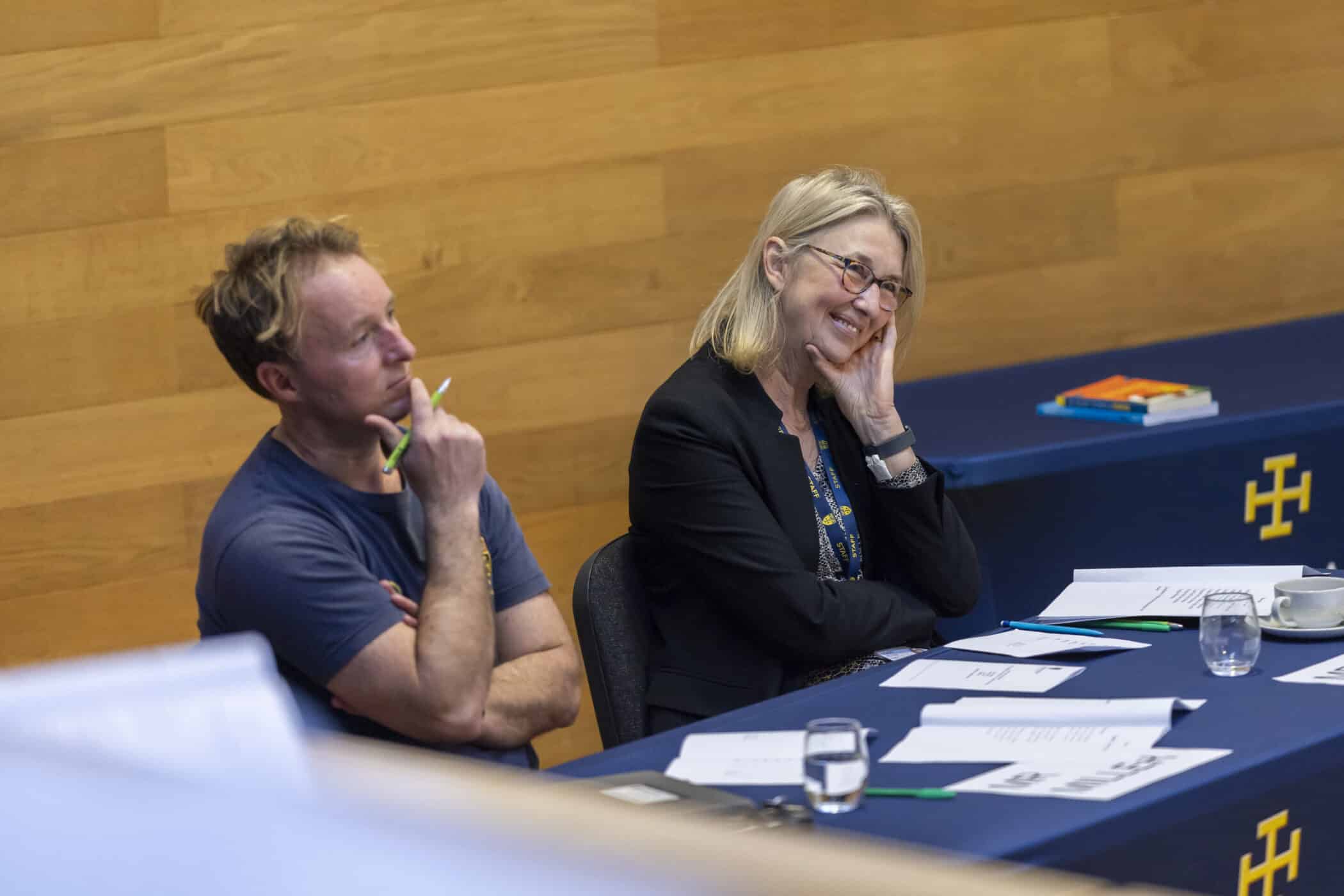 Two teachers look on as students present in a competition