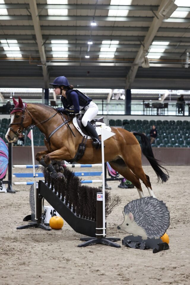 Cranleigh pupil jumping over a barrier on a horse.