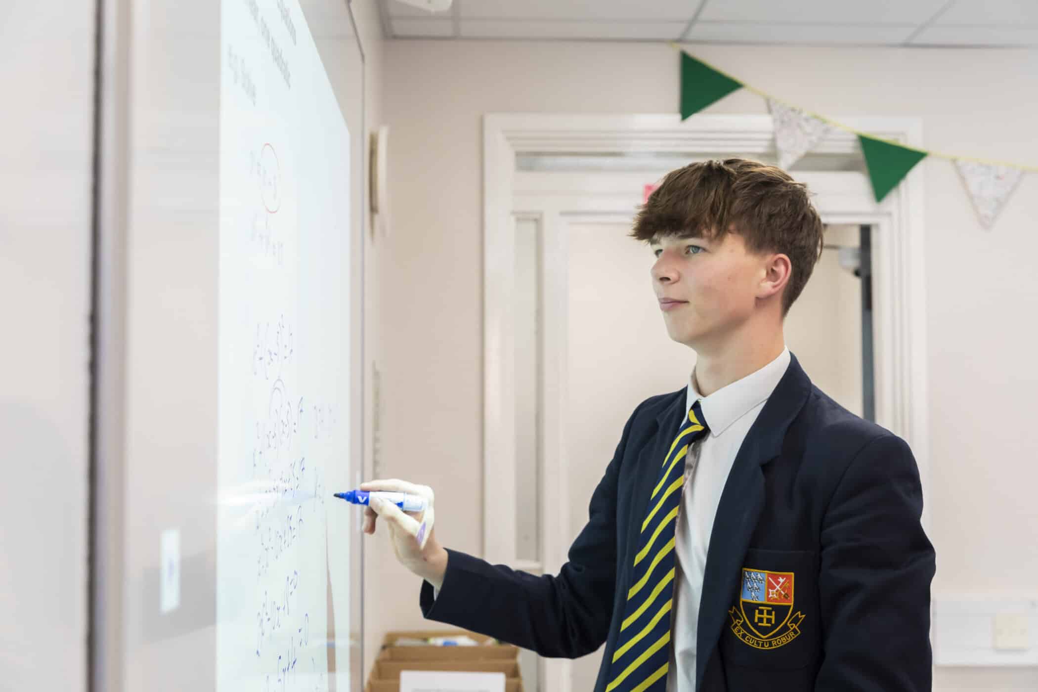 Pupil in maths class writing on the board